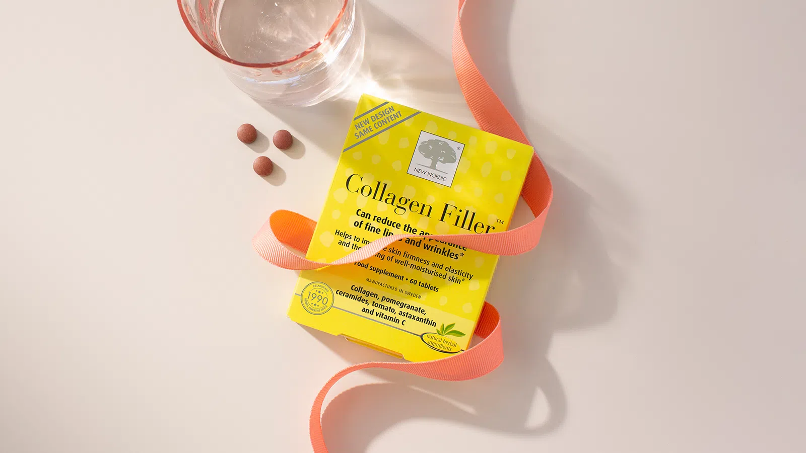 Collagen Shot™ 19 Collagen Filler™ displayed with a glass of water, tablets, and ribbon.