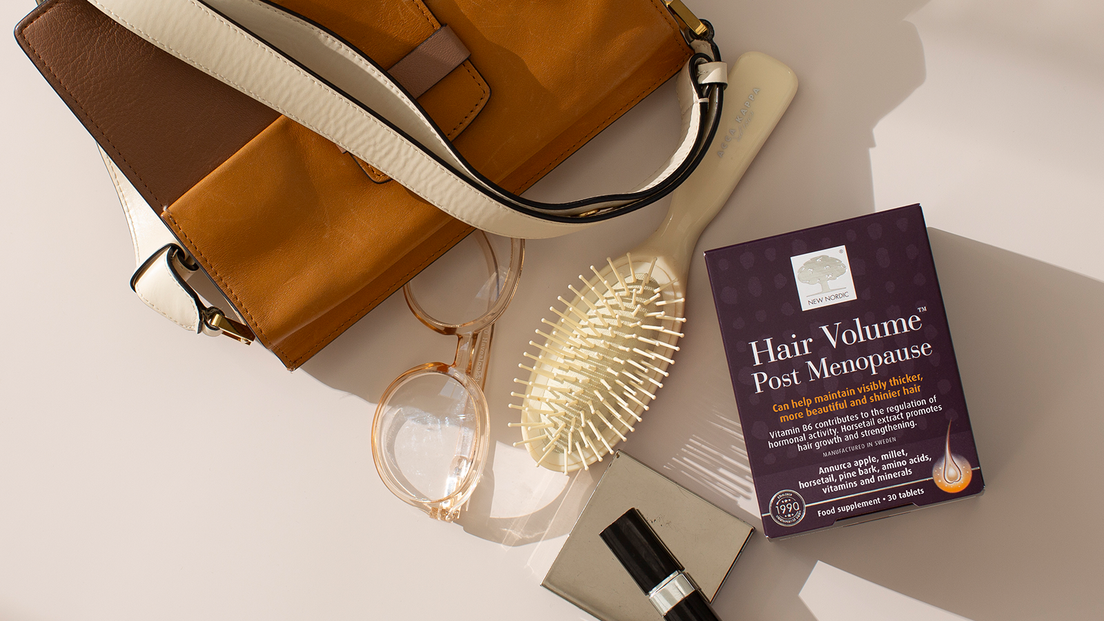 Enhanced Hair Quality with Hair Volume™ Post Menopause 29 New Nordic Hair Volume™ Post Menopause displayed with personal items on a light surface.