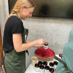 Herbal Schools 35 Woman experimenting with herbs at a herbal school event, learning about and engaging with plants.
